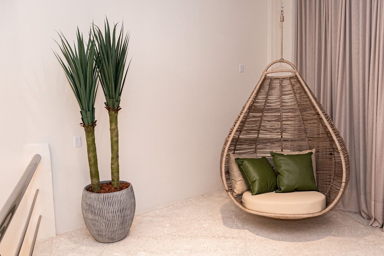 Poltrona suspensa de fibra natural no showroom da La Decor