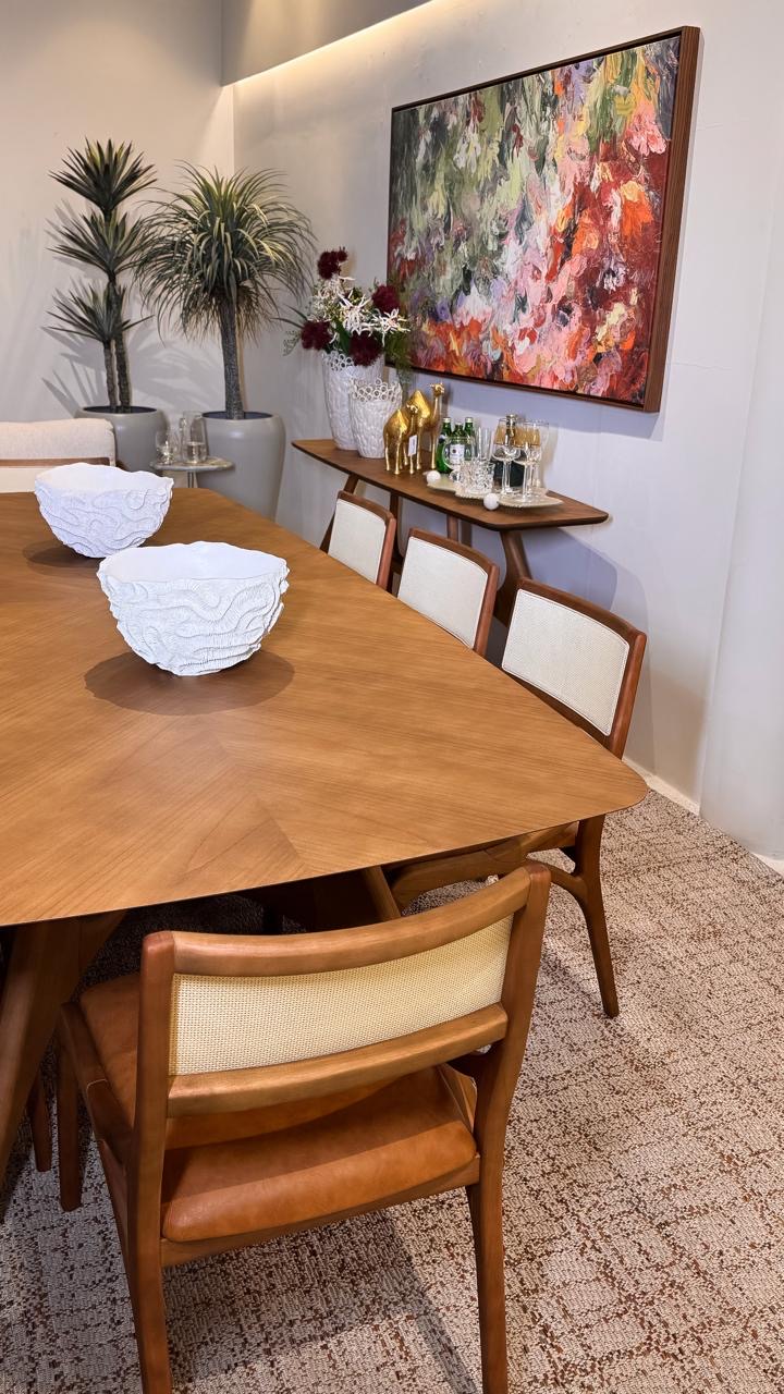Sala de jantar com mesa de madeira e arte no showroom da La Decor em Itabuna